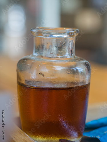 a Bottle of syrup, brown clear syrup in a small jug for coffee.