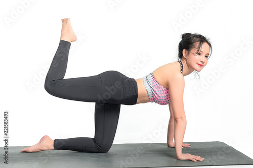 Young Asian woman practicing yoga on white bsckground.