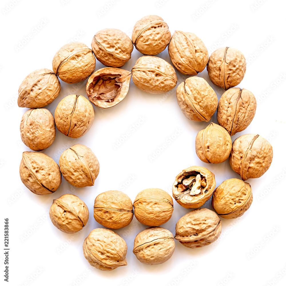 whole walnuts circle with two cracked nuts isolated on white whole walnuts circle with two cracked nuts isolated on white
