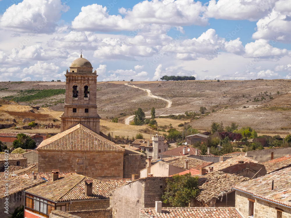Belltower of the 16th century parish church of the Conception tucked down in a small valley of the Meseta - Hontanas, Castile and Leon, Spain