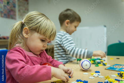 Caucasian children plying with hwooden toys in kindergarten