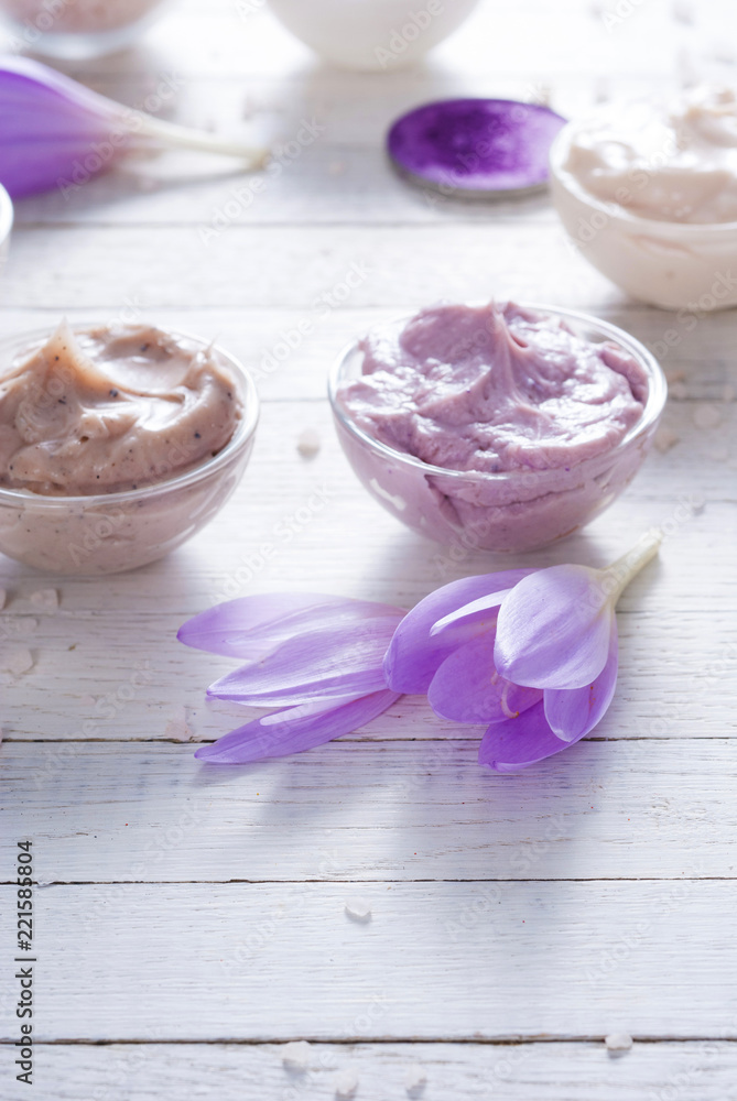 beauty product samples and autumn crocus herbal flower on white wooden table beauty product samples and autumn crocus herbal flower on white wooden table