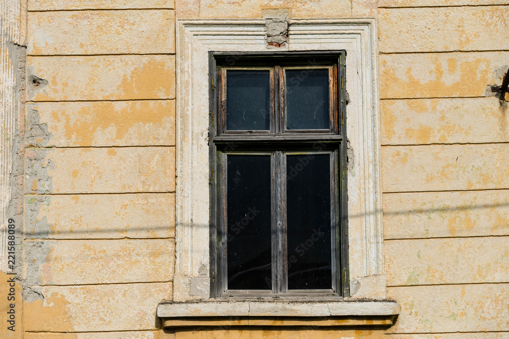 Fototapeta premium Old window on abandoned residentual house close up shot on a sunny day.