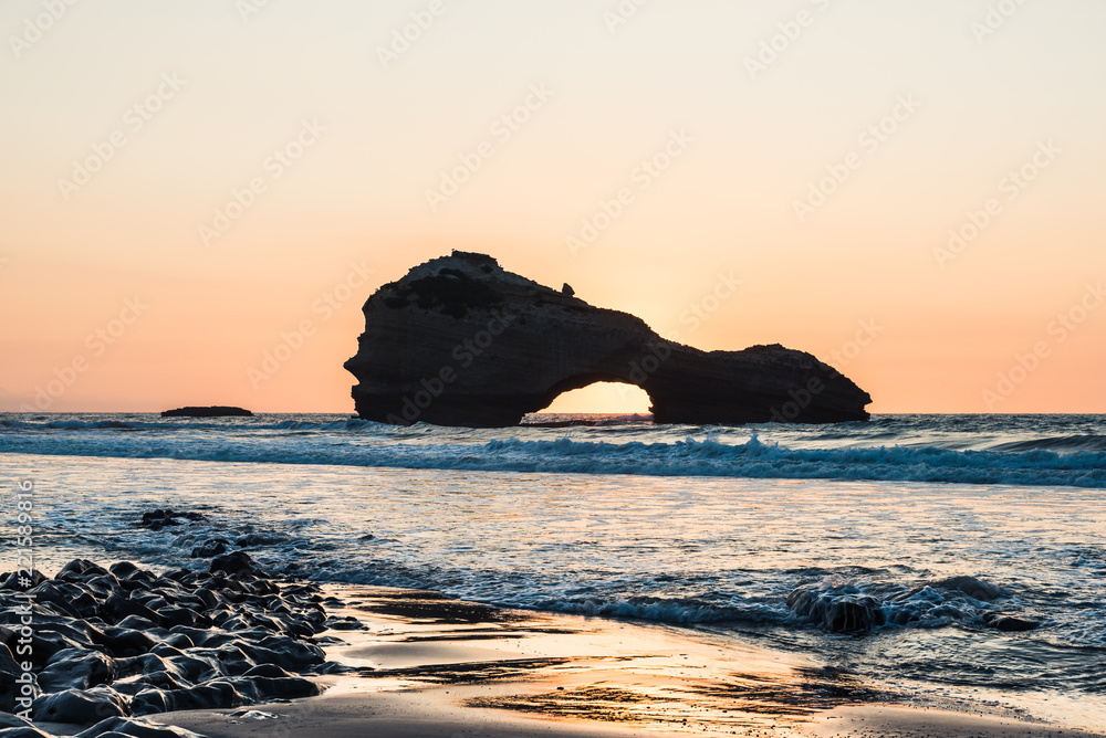 Beach in Biarritz at sunset time with a rock in the ocean. Basque country of France.