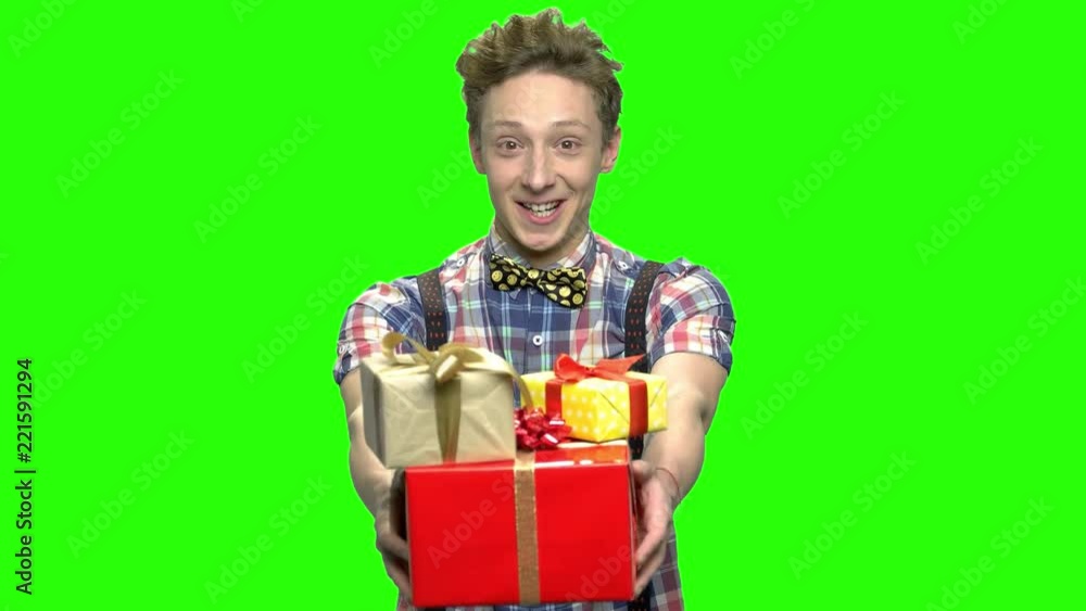 Handsome teen boy giving gift boxes. Congratulate with birthday or christmas. Green screen hromakey background for keying. Handsome teen boy giving gift boxes. Congratulate with birthday or christmas. Green screen hromakey background for keying.