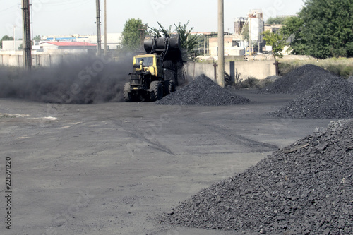 Warehouse for retail sale of coal to the population with a loading excavator. Trade in natural resources and minerals. Heating season in houses. Energy for thermal power plants, indystry photo