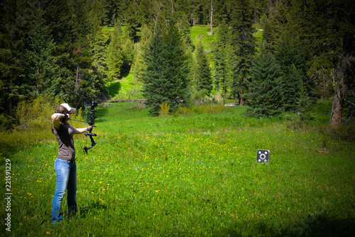 Woman using a bow during archery target practice.