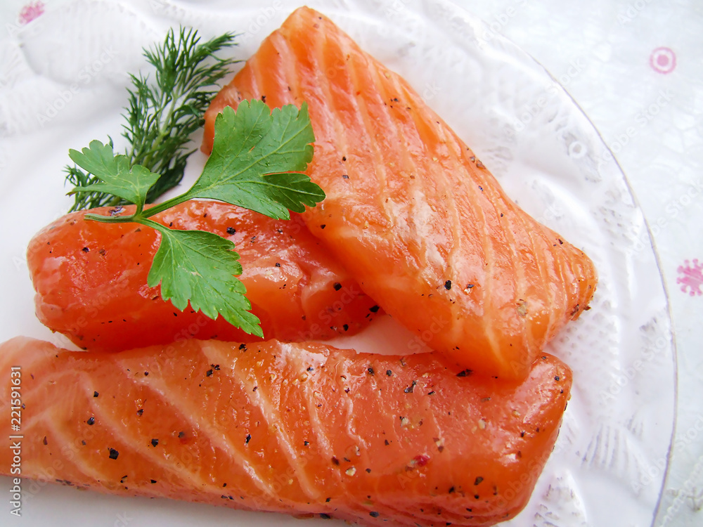 pieces of red marinated salmon on a white plate pieces of red marinated salmon on a white plate