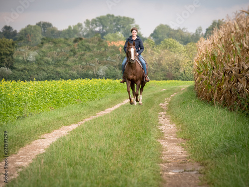 Junge Frau auf Pferd im Galopp