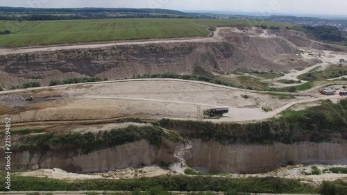 Aerial shot of landfill with working excavator moving garbage. photo