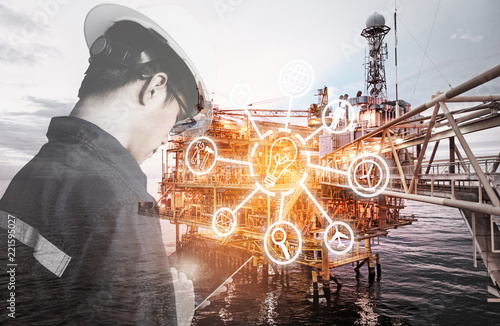 Double exposure of Engineer or Technician man with digital icon operated platform or plant by using tablet with offshore oil and gas platform background for industry business concept photo