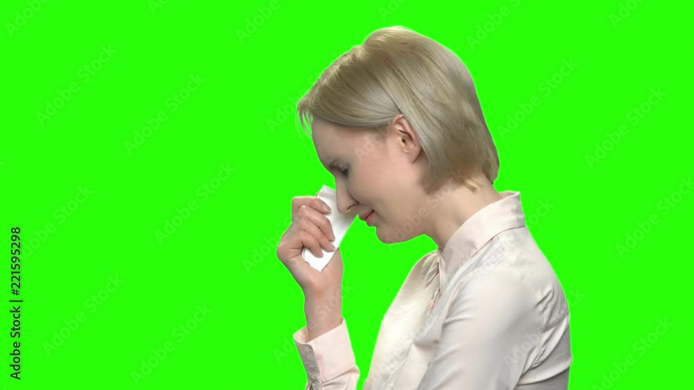 Sad woman crying with handkerchief. Side profile view. Green hromakey background for keying. Sad woman crying with handkerchief. Side profile view. Green hromakey background for keying.