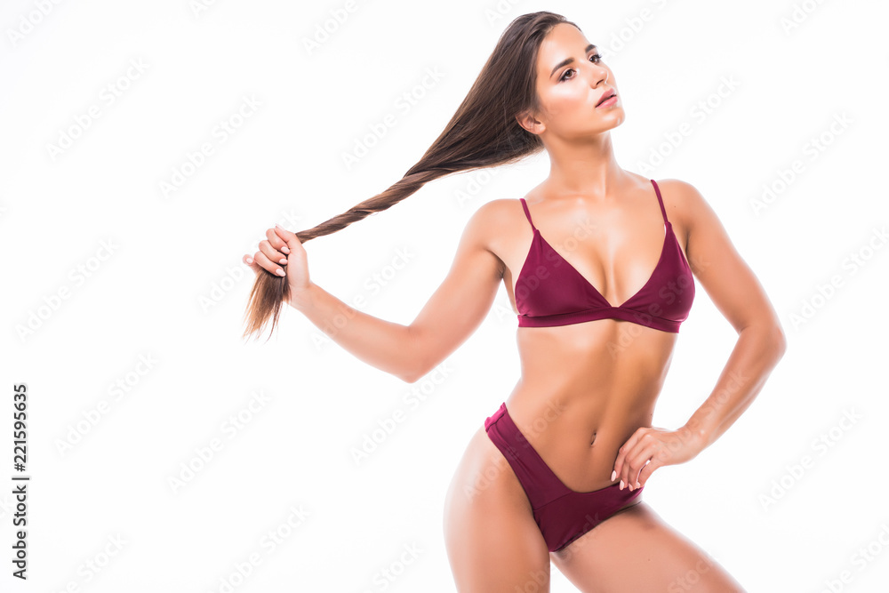 Sexy young brunette woman with large breasts and her hair in hands posing  in a bikini on white background Stock Photo