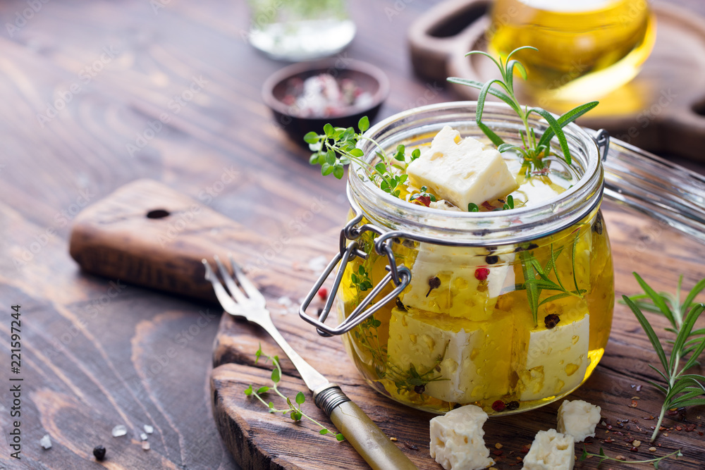 Feta cheese marinated in olive oil with fresh herbs in glass jar. Wooden  background. Copy space. Stock Photo | Adobe Stock