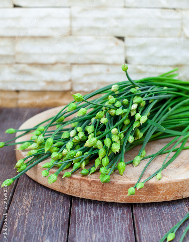 Chives flower, Garlic chives or Chinese Chive on a cutting board. Wooden background. Chives flower, Garlic chives or Chinese Chive on a cutting board. Wooden background.