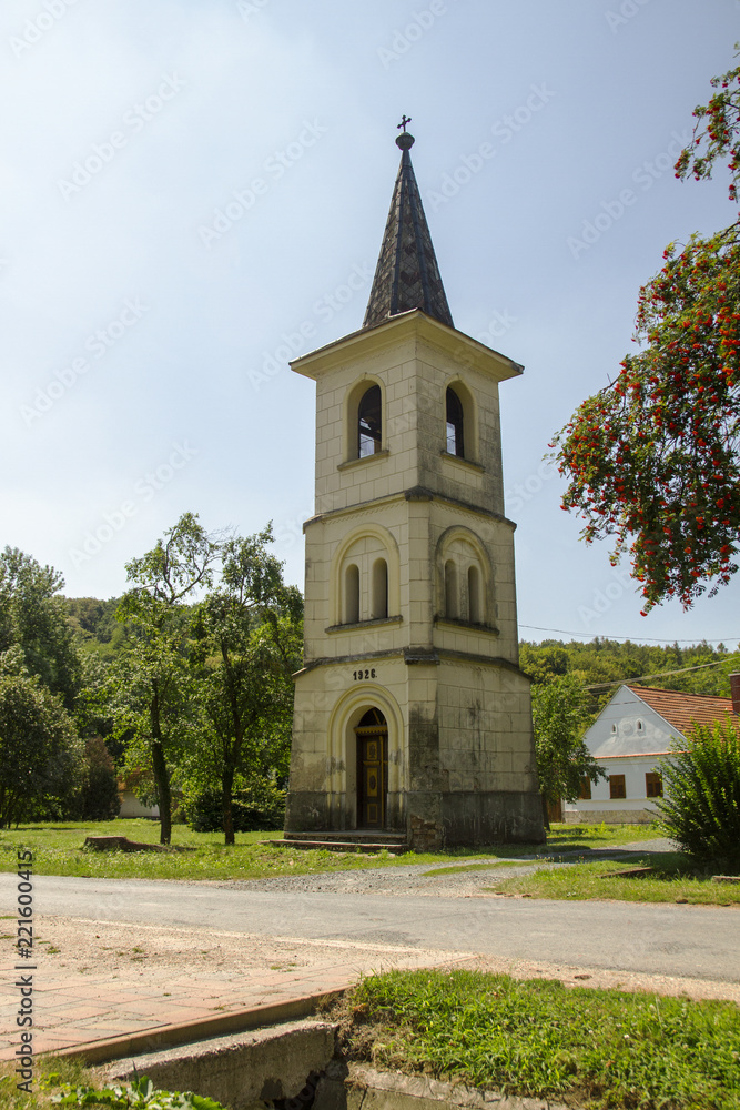 Historic chapel with belfry. Old Bell tower in small town in Hungary. Hungarian village.