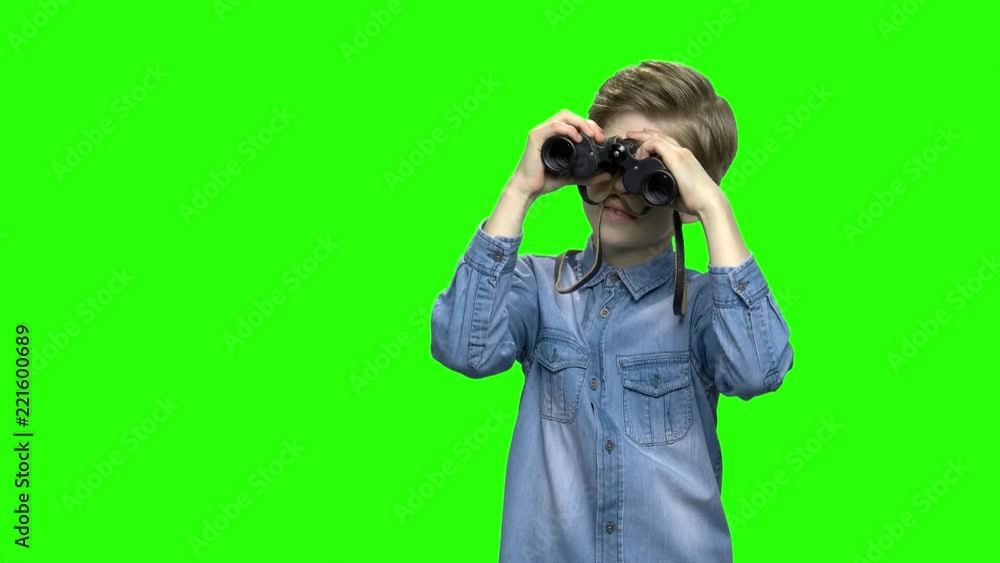 Child boy tourist looking through binoculars. Green hromakey background for keying. Child boy tourist looking through binoculars. Green hromakey background for keying.