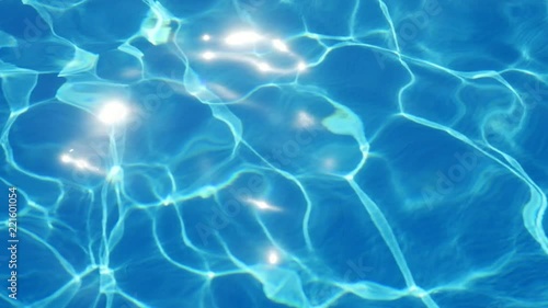 A wonderful view of celeste waters in a swimming pool with shining network shifting its shape impressively in summer in slow motion