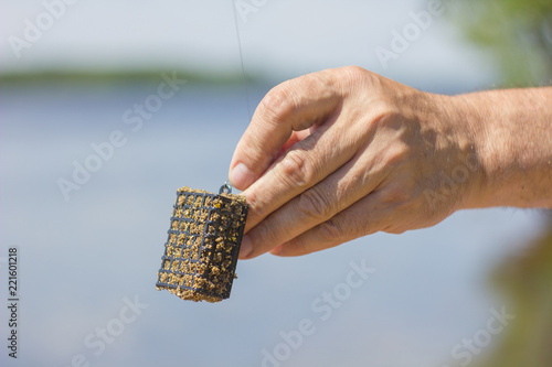 the fisherman holds in his hand a feeder with feeding fish