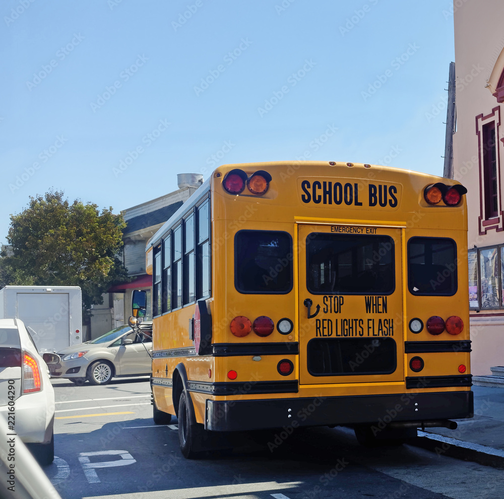 Rear view of school bus in city traffic.