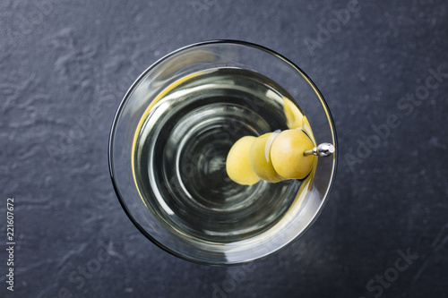 Martini cocktail with green olives. Slate background. Top view. Close up.