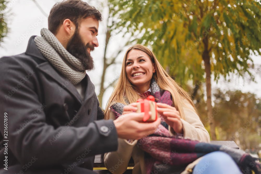 Man giving surprise gift to woman in the park Man giving surprise gift to woman in the park