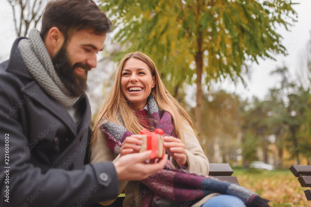 Man giving surprise gift to woman in the park Man giving surprise gift to woman in the park