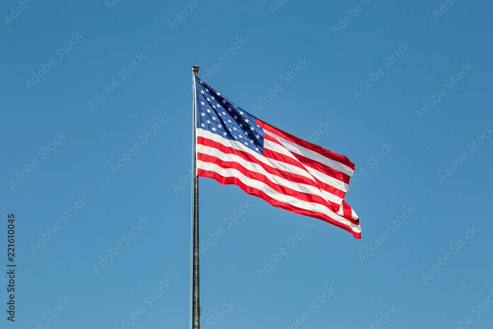 The US flag flying against a clear blue sky
