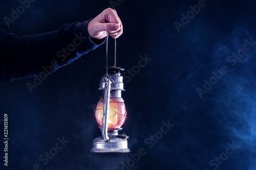 Canvas Print Man hand holding gas lantern on dark and night smoked foggy background