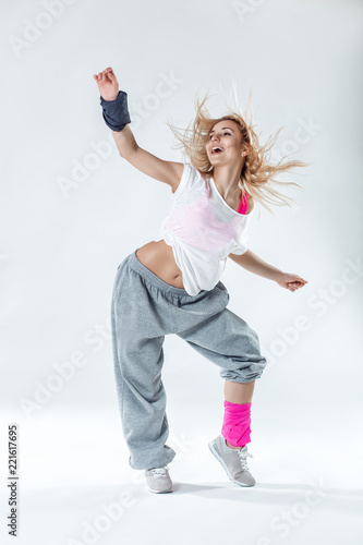 Young beautiful slim girl dancing on a white studio background
