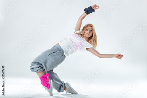 Young beautiful slim girl dancing on a white studio background