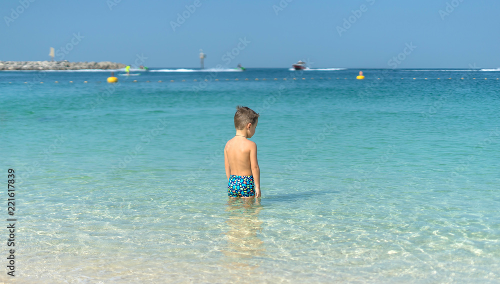 Portrait little boy playing in the sea, ocean. Happy family having fun on tropical white beach. Positive human emotions, feelings. Funny cute child making vacations and enjoying summer. Portrait little boy playing in the sea, ocean. Happy family having fun on tropical white beach. Positive human emotions, feelings. Funny cute child making vacations and enjoying summer.