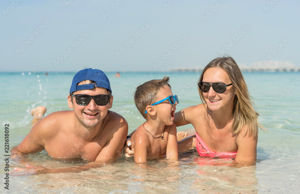 Happy family having fun on tropical white beach. Mother, father, a cute son. Positive human emotions, feelings, joy. Funny cute child making vacations and enjoying summer. Spring and summer holidays. Happy family having fun on tropical white beach. Mother, father, a cute son. Positive human emotions, feelings, joy. Funny cute child making vacations and enjoying summer. Spring and summer holidays.