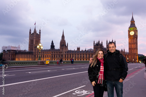 Couple of middle-aged tourists in London during the sunset with the House of Parliament in the background