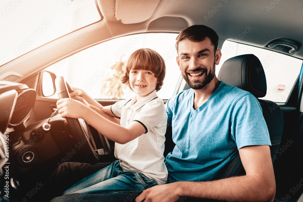 Man With Son Are Sitting At The Wheel Of New Car. Man With Son Are Sitting At The Wheel Of New Car.