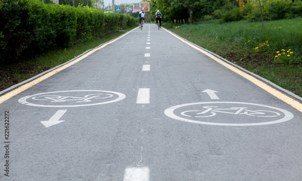 Obraz premium Painted signs on asphalt for bicycle dedicated lanes. A separate bike path in the city, cyclists on the cycle track