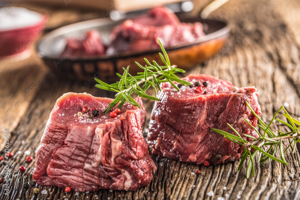 Close-up slices of beef tenterloin steak salt pepper and rosemary