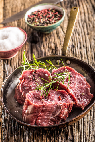 Close-up slices of beef tenterloin steak salt pepper and rosemary