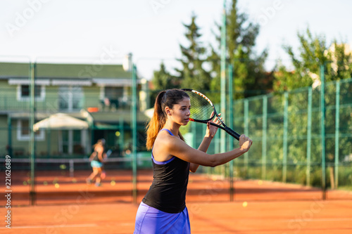 Beautiful teenage girl  practicing tennis on outdoor tennis court. © hedgehog94