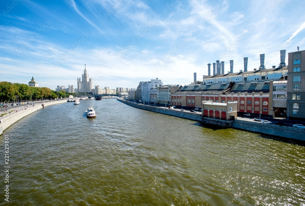 Fototapeta premium View from new floating bridge of Zaryadye Park on Embankment of Moscow river with The Moscow Orphanage, Skyscraper (Vysotka) on Kotelnicheskaya quay and hydroelectric power station HPP 1. 