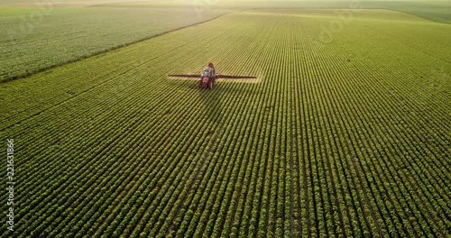Aerial drone shot of a farmer spraying soybean fields