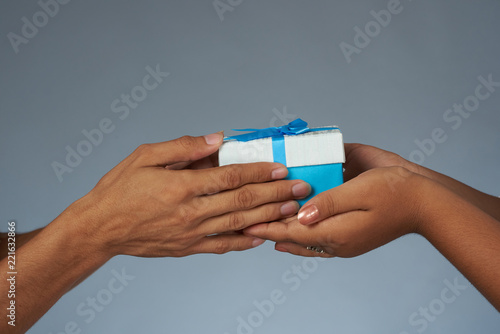 Hands holding blue gift box