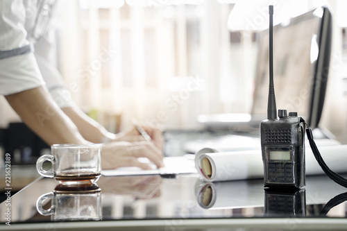 Quadro em tela Two way radios on table with blur background of men working