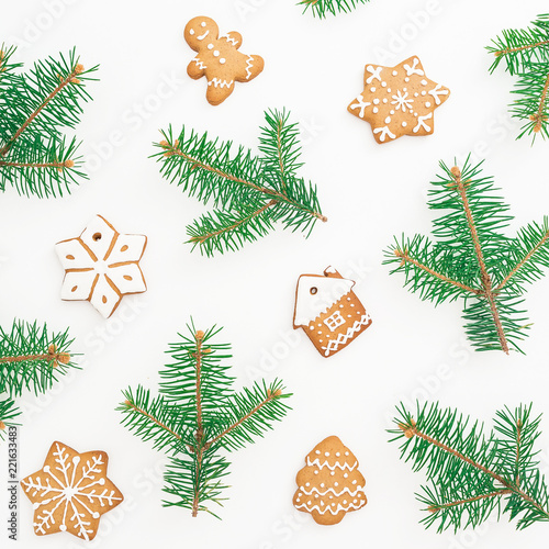 Christmas gingerbread cookies and natural fir branches on white background. Flat lay, top view. New Year pattern