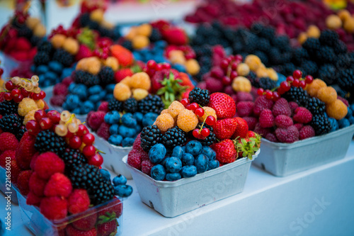 Fresh different berries in the plastic cup at Europe dong street berries and exotic fruits at market streetshop. Assortment festive appetizers in the cup, selective focus. photo