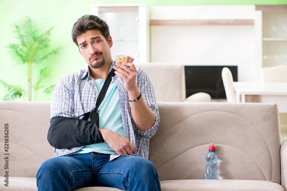 Young student man with hand injury sitting on the sofa Young student man with hand injury sitting on the sofa