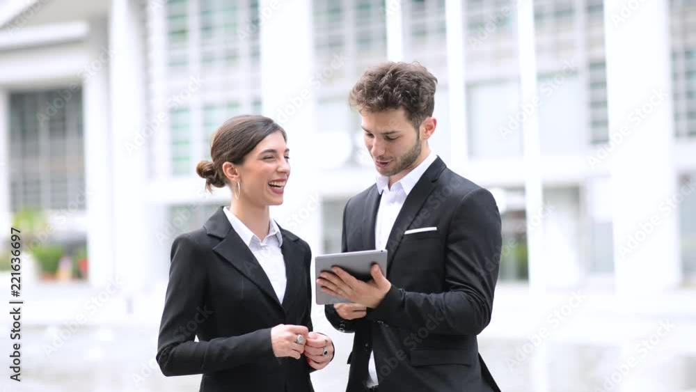 Couple of business people using a tablet outdoor Couple of business people using a tablet outdoor
