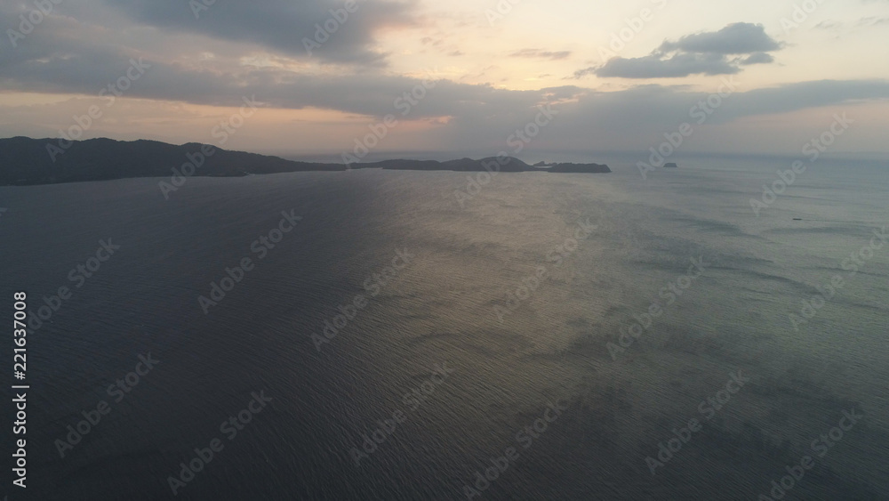 Aerial view of coast of the island at sunset. Anilao, Caban Island, Philippines, Luzon. Travel concept.