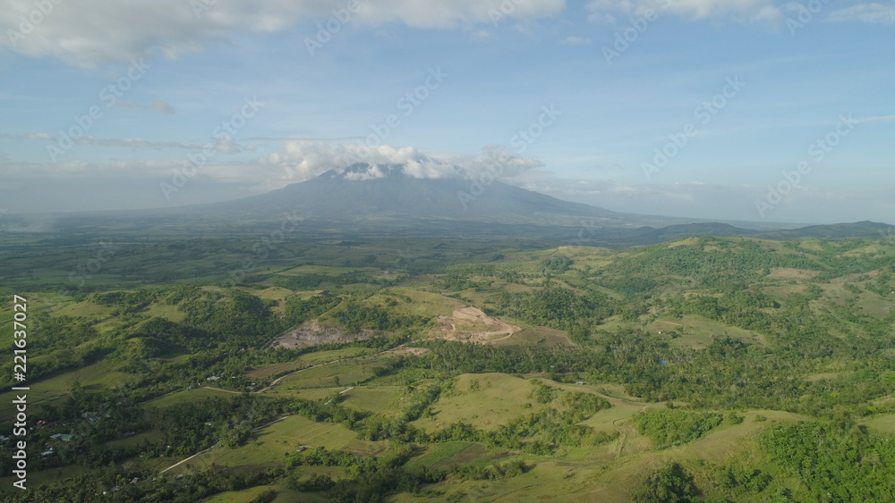 Aerial view of mountain valley with hillscovered forest, trees, mount Iriga. Luzon, Philippines. Slopes of mountains with evergreen vegetation. Mountainous tropical landscape. Aerial view of mountain valley with hillscovered forest, trees, mount Iriga. Luzon, Philippines. Slopes of mountains with evergreen vegetation. Mountainous tropical landscape.