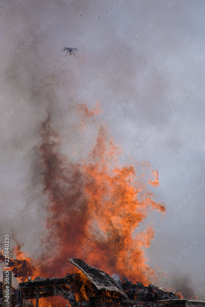 A drone hovers over a raging structure fire